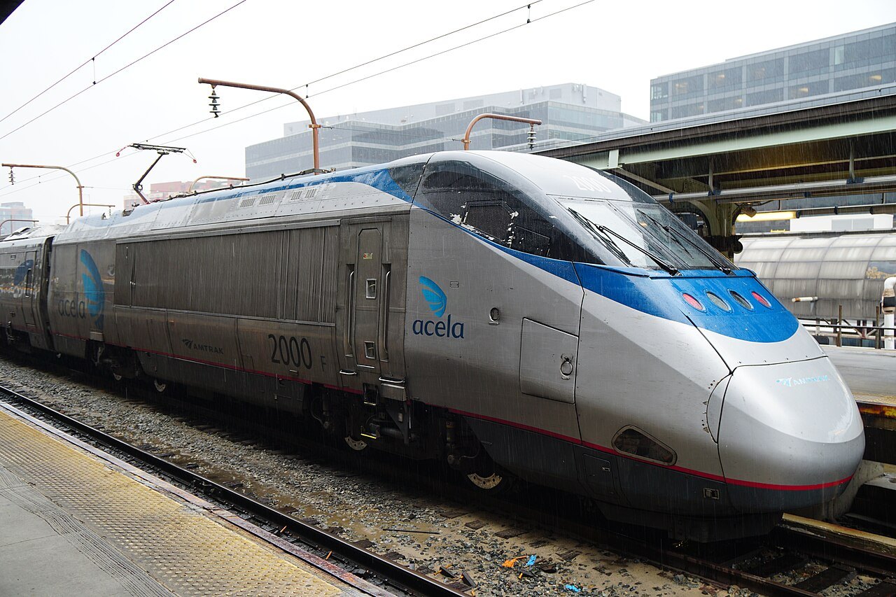 An Acela train at the platform under the Union Station train shed