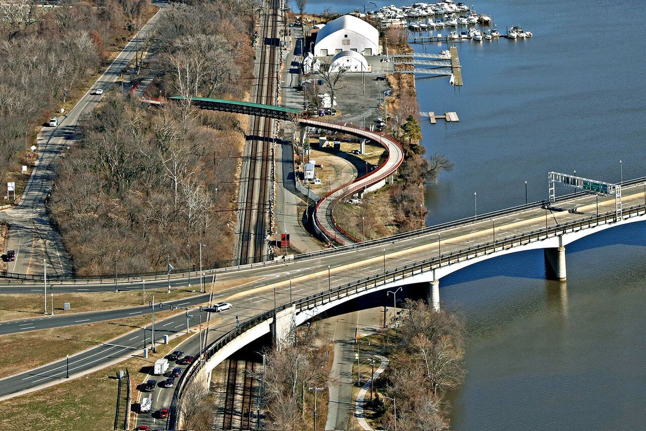 The Anacostia Riverwalk Trail curving under a bridge by the river in Southeast
