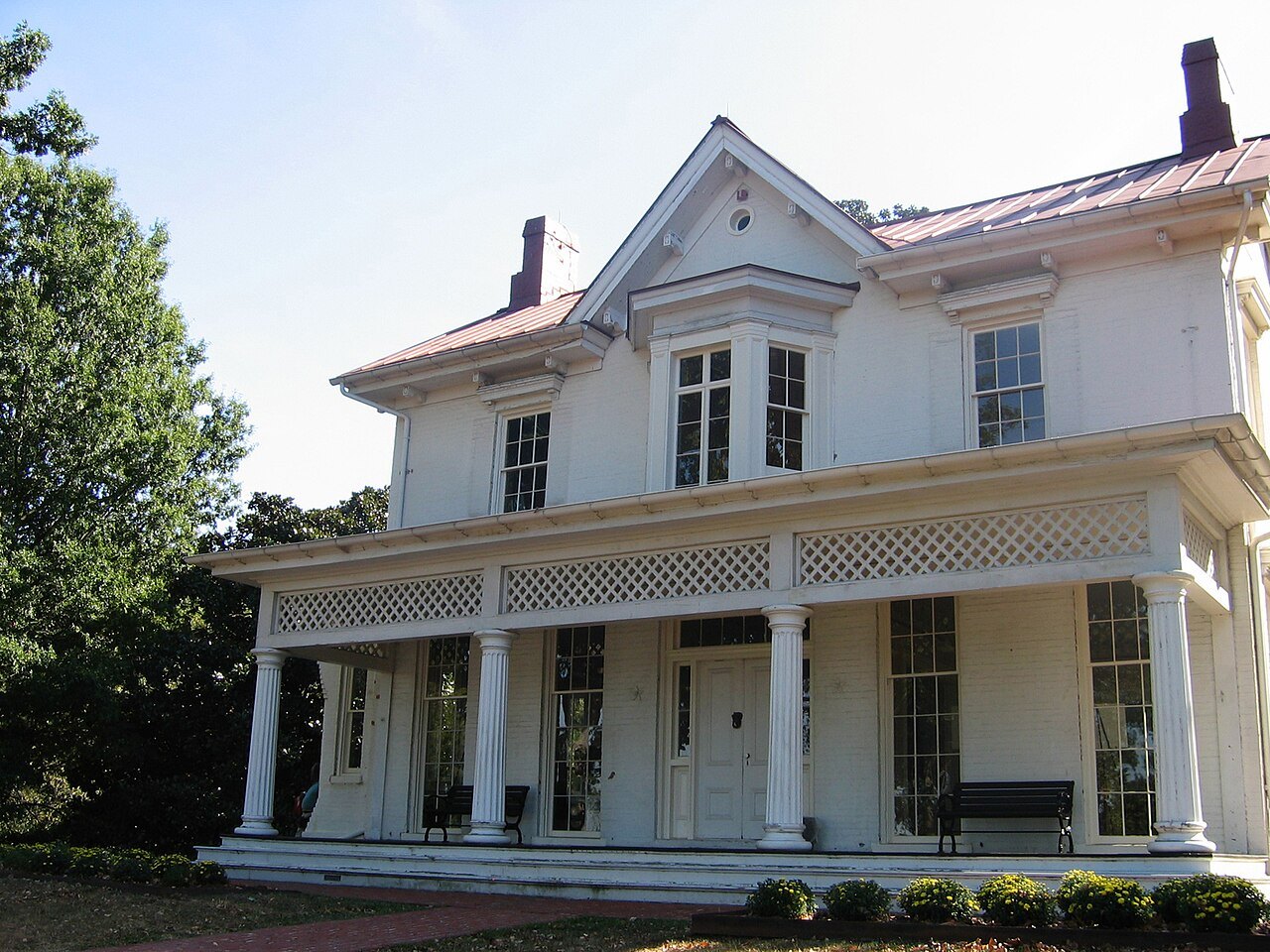 The front of Cedar Hill and its long porch in bright sun