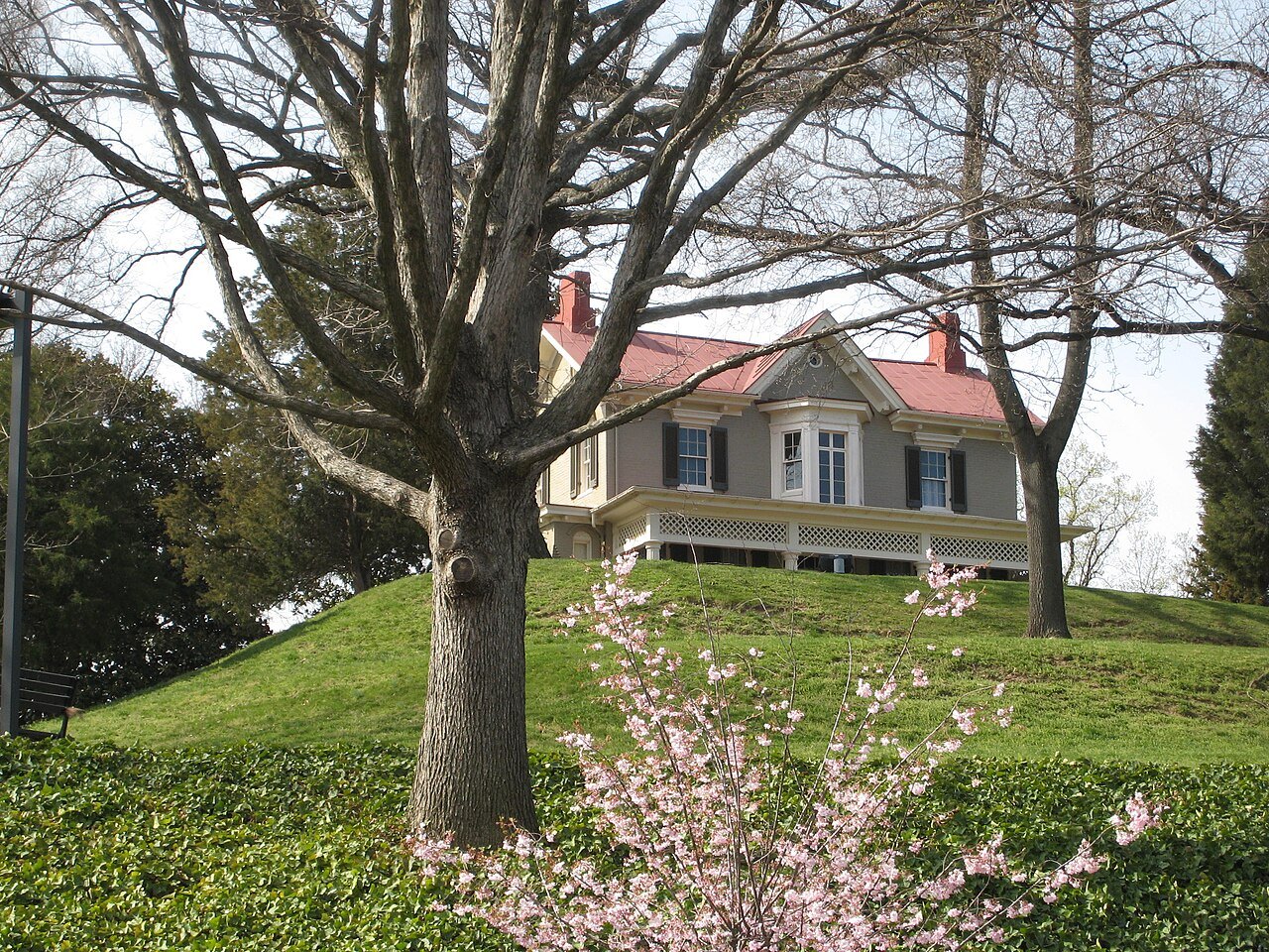 Cedar Hill seen up the hill through trees in spring blossom