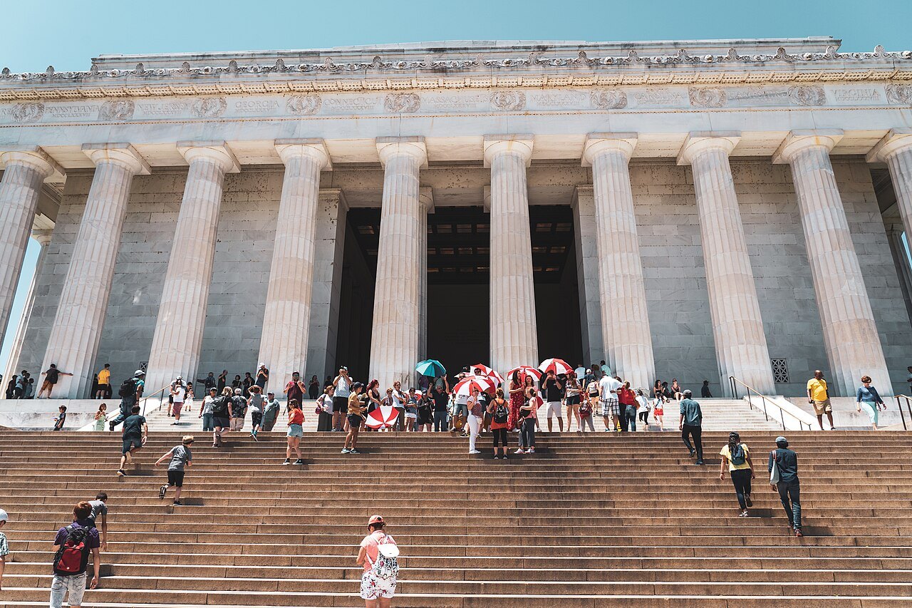 Visitors climbing the steps of the Lincoln Memorial toward its colonnade