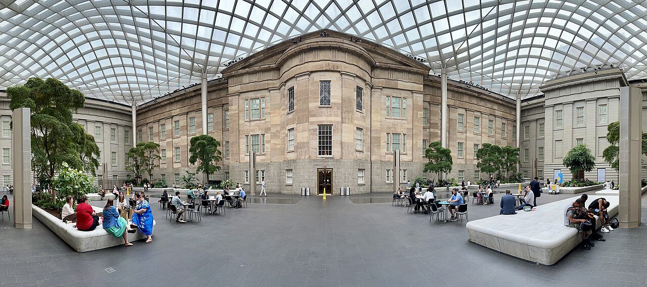 The Kogod Courtyard between the Old Patent Office's wings, people at tables below the canopy