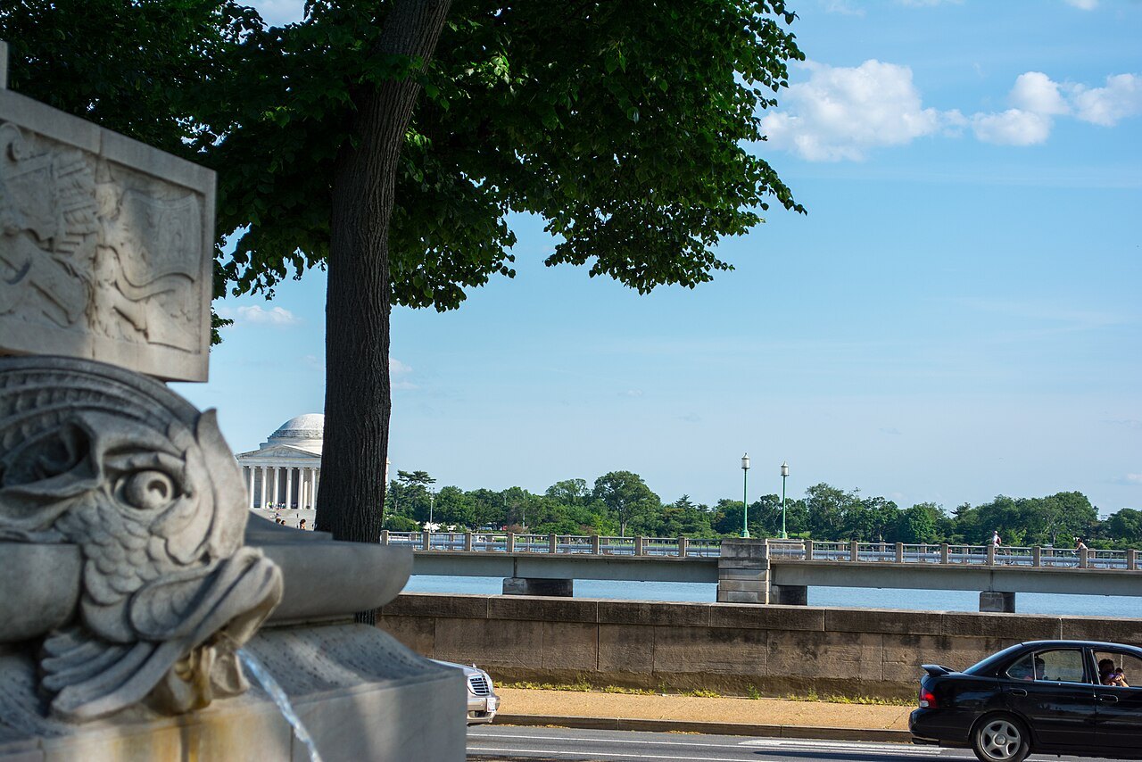 A carved fish on the Kutz Bridge parapet, the Jefferson Memorial across the water