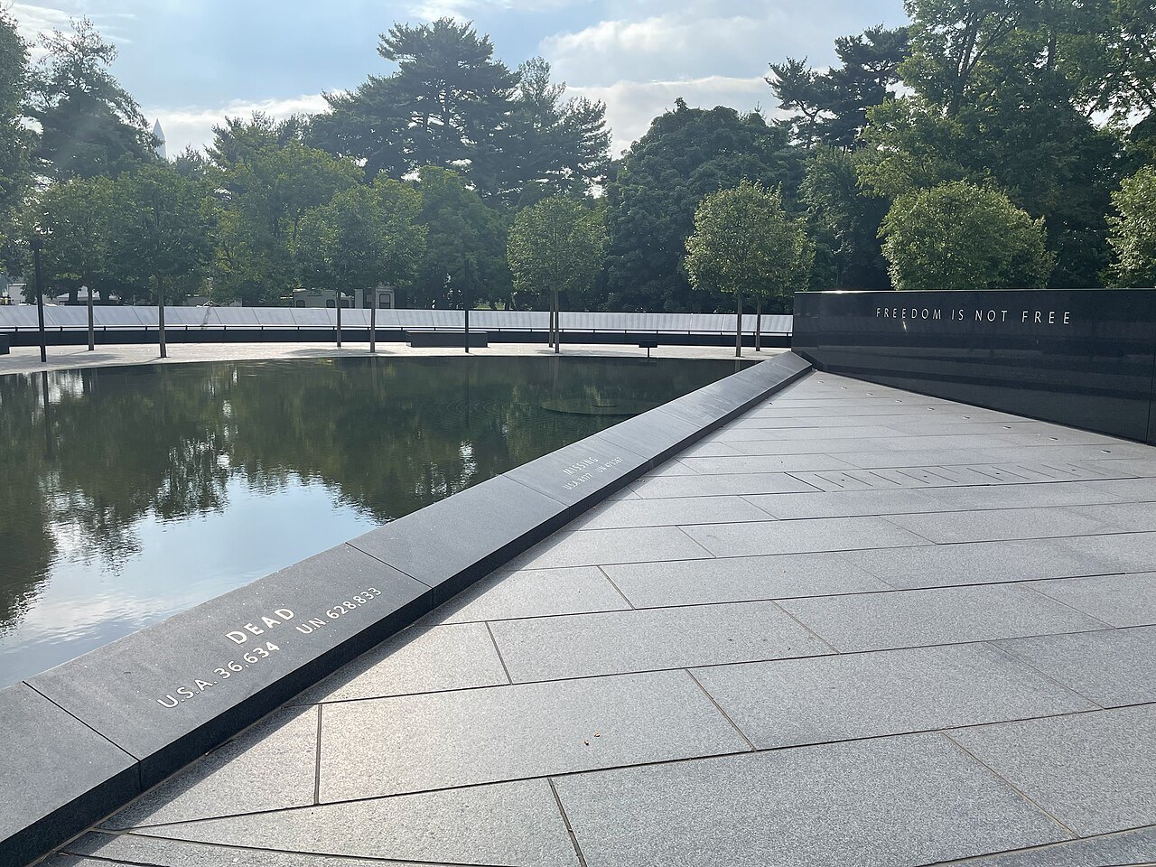 The Wall of Remembrance beside the pool, names carved in the granite