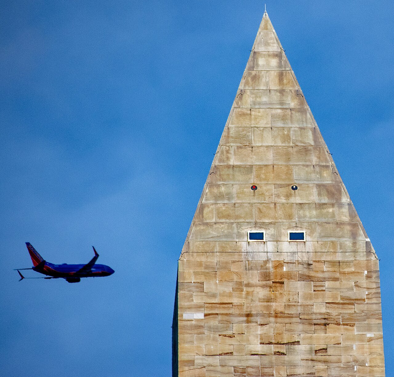 The pyramidion at the top of the Washington Monument, a plane passing